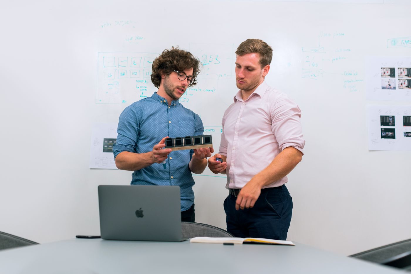 Two engineers discussing a design at a whiteboard